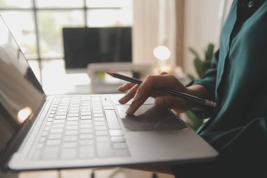 Kadın Yönetici envanteri kontrol etmek için dizüstü bilgisayar kullanıyor. Karton kutularla, e-ticaret çevrimiçi siparişlerle, yiyecek, ilaç ve ürün tedarikleriyle birlikte arka plandaki depo perakende satış merkezinde. Omzunun üstünden.