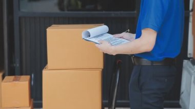 Ofisinde karton kutular ve kalemle üniformalı teslimatçı. dağıtım servisi.