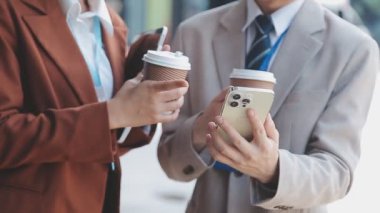 Resmi görevdeki iki iş kadını ofiste bir fincan kahve içerler.