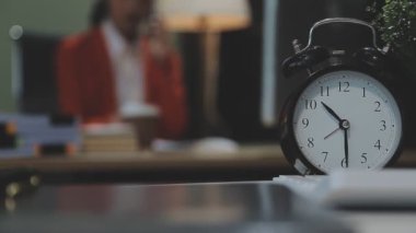 Masadaki saat bulanık ışıklarla.