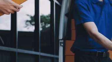 Mavi gömlekli ve siyah üniformalı genç Asyalı adam.