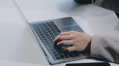 ofiste dizüstü bilgisayarda çalışan genç kadın