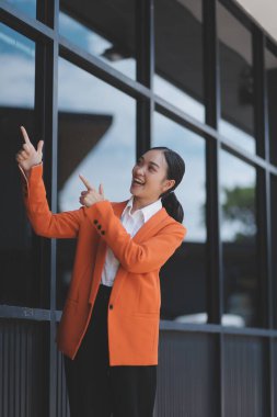 Modern iş binasının önünde dijital tablet kullanan başarılı bir iş kadınının portresi