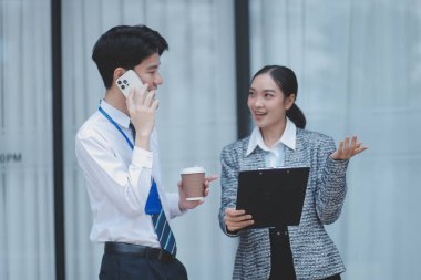 Ofisteki iş arkadaşları ofis binasının dışında yeni projeleri tartışıyor, dijital tablet tutuyorlar. Ofis binalarının önünde duran iki iş arkadaşı iş planını tartışıyor.