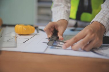 Mühendisler toplantı yapıyor ve ofiste bir planı tartışıyorlar. Mühendislik araçları ve inşaat konsepti