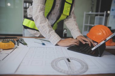 Mühendisler toplantı yapıyor ve ofiste bir planı tartışıyorlar. Mühendislik araçları ve inşaat konsepti