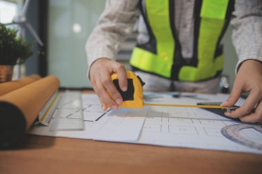 Mühendisler toplantı yapıyor ve ofiste bir planı tartışıyorlar. Mühendislik araçları ve inşaat konsepti