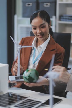 kadın alternatif enerji mühendisi bir yel değirmeni güç örnek model tutun ve stüdyoda alternatif güç kaynağı için onun erkek arkadaşı ile tartışmak