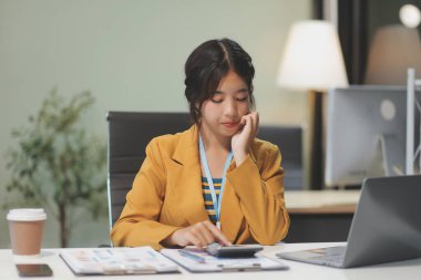 Modern ofis odasında dizüstü bilgisayarla projesinde çalışan çekici genç bir iş kadını..