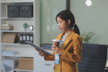 Modern ofis odasında dizüstü bilgisayarla projesinde çalışan çekici genç bir iş kadını..