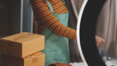 Karton bir paket taşıyan bir kadın.