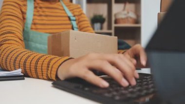 Kadın elinde dizüstü bilgisayar ve paket kutusu ile ahşap masa. çevrimiçi dağıtım kavramı