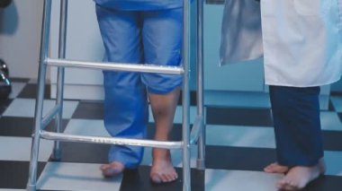 Doktor üniformalı koltuk değnekleriyle yürüyor.