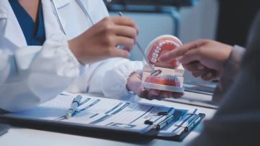 Bir hastanın dişlerini muayene eden bir doktor.