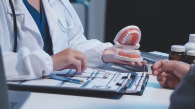 Hastaya dişlerini gösteren dişçi