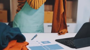 Evde dizüstü bilgisayarla çalışan ve internetten alışveriş yapan bir kadın..