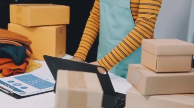 Teslimat hizmeti kavramı. Önlüklü kadın işçi paketini tutuyor ve ofiste paket kutuları paketliyor..