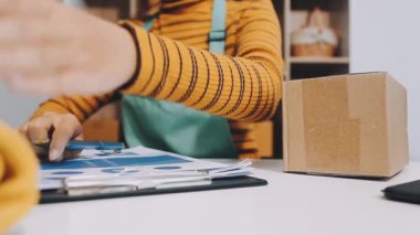 Karton bir kutu ve akıllı telefon tutan bir kadın.