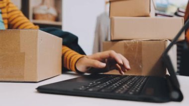 Dizüstü bilgisayarda bir paket tutan bir kadın.