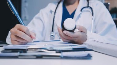 Doktor elinde haplarla reçete yazıyor.
