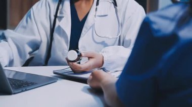 Doktor ofiste hastayla bilgisayarla uğraşıyor.