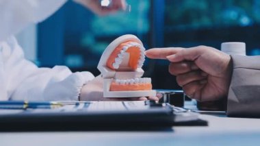 Hastaya dişlerini gösteren dişçi