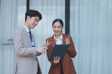 Başarılı genç iş adamları modern iş binası önünde konuşuyor, birlikte çalışıyorlar.