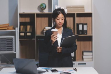 Genç Asyalı kadın portresi modern ofiste bilgisayar tableti üzerinde çalışıyor. Muhasebe analizi yapmak gayrimenkul yatırım verileri, mali ve vergi sistemleri kavramı.