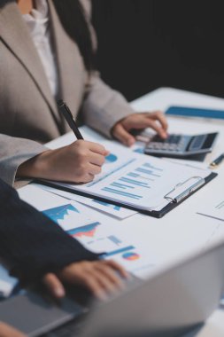 Modern dizüstü bilgisayarla gelir tabloları ve grafiklerini analiz eden iş ekibini kapatın. İş analizi ve strateji kavramı.