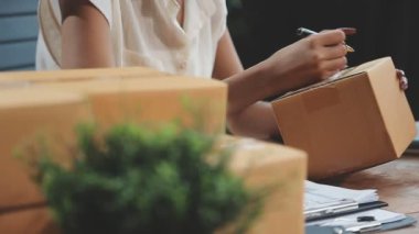 Kadın ahşap arka planda kalem ve defter tutuyor..