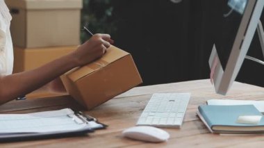 Bilgisayarı kullanan ve dizüstü bilgisayarda çalışan genç bir kadın..