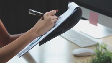 Genç iş kadını tablet bilgisayar kullanıyor ve ofiste yazıyor.