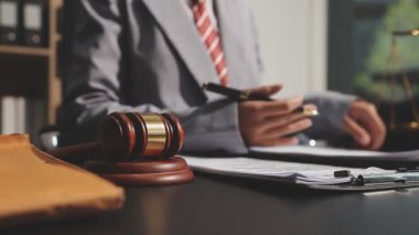 Yargıç Tokmak, adalet terazisi, avukatlar laptopla ve evraklarla büroda çalışıyor..