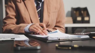 Genç adam ofiste bir defterle çalışıyor..