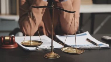 Adalet hukuku kavramı. Avukat ya da yargıç tokmağı, terazili teraziler, tokmak, adalet ve kitaplar masanın üstünde..