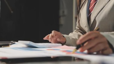 İşadamı kağıda not yazıyor.