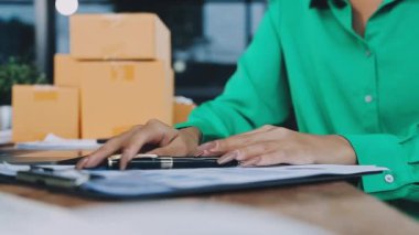 Genç Asyalı iş kadını online alışveriş yapmak için tablet kullanıyor..
