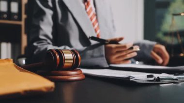 Yargıç Tokmak, ahşap masadaki belgeler ve dizüstü bilgisayarla.