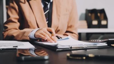 Elinde belgeler olan takım elbiseli genç adam.