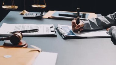 Avukat müvekkil ile çalışıyor, yasal belgeler ve belgeler büro masasında..