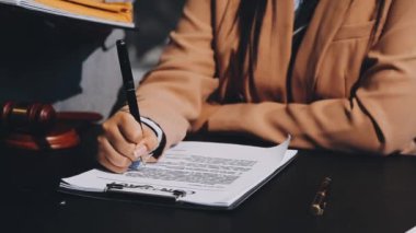 Yakın plan - bir kadının ellerinin kalem tutması, not defterine bir not yazması, siyah masa, iş konsepti, klasik ton