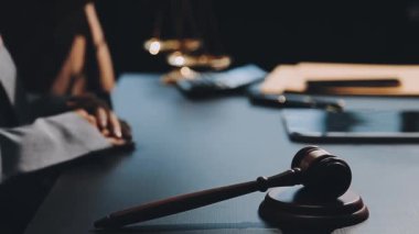 Mahkeme salonunda tokmak ve belgelerle çalışan avukat ya da yargıç.