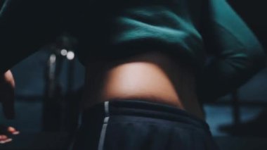 Siyah arka planda beyaz gömlekli siyah iç çamaşırlı bir kadın.