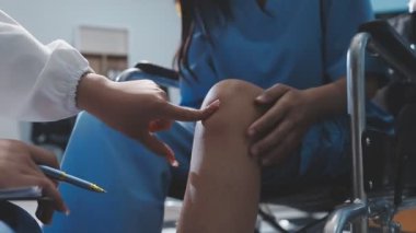 Doktor hastane koğuşundaki hastanın bacağını kontrol ediyor. Orijinal fotoset.