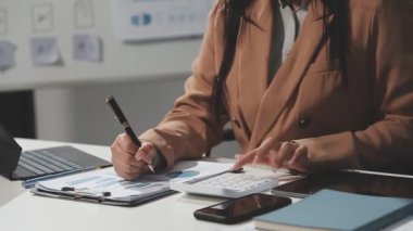 İş kadını ofisteki masada not defterine yazı yazıyor.