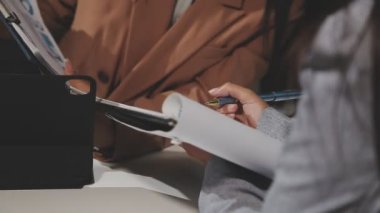 Takım elbiseli bir iş kadını not yazıyor.