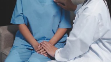 Genç bayan doktor hastayı el ele tutuyor. Sağlık ve Tıp Konsepti