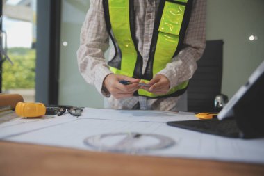 Mühendisler toplantı yapıyor ve ofiste bir planı tartışıyorlar. Mühendislik araçları ve inşaat konsepti