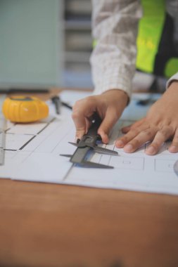 Mühendisler toplantı yapıyor ve ofiste bir planı tartışıyorlar. Mühendislik araçları ve inşaat konsepti