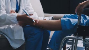 Doktor bir hastanın elini tutuyor.